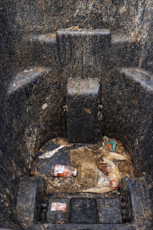 Inside a garbage bin before cleaning: caked-on grime and leftover trash